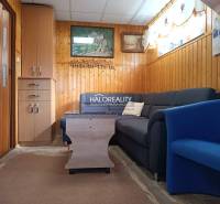 Nappali a házban kanapéval, fotellel és falburkolatokkal.