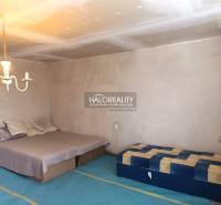 Hálószoba családi házban ággyal, matraccal, lámpával és egyszerű bútorokkal.