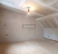 Családi ház be nem rendezett tetőtéri szoba, világos falak és fa padló.