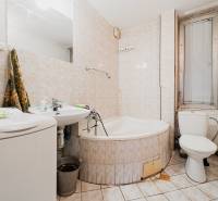 Kúpeľňa s vaňou, umývadlom a práčkou v rodinnom dome.