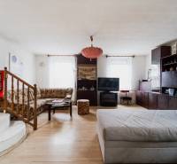 Nappali egy családi házban, fa dekorációjú padlóval és kényelmes ülőgarnitúrával.