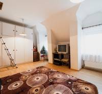 Szoba egy családi házban fa dekor padlóval, televízióval és szekrénnyel.