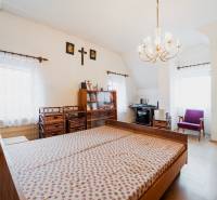 Hálószoba családi házban, fa mintázatú padlóval, ággyal és dolgozósarokkal.