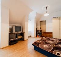 Hálószoba családi házban fa dekor padlóval, régebbi televízióval és tárolóhellyel.