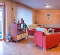 Nappali egy villában piros kanapéval és fa dekorációjú padlóval.