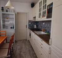 A háromszobás lakás konyhája faasztallal, szekrénnyel és növényekkel.