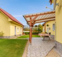 Kert a családi ház mellett Bésen terasszal és gondozott gyeppel.