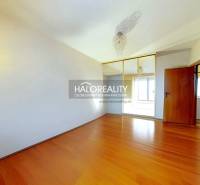 Szoba egy háromszobás lakásban, fa dekoros padlóval és beépített szekrénnyel.