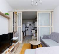 Nappali egy kétszobás lakásban konyhával és fa dekorációjú padlóval.