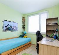 Gyerekszoba egy kétszobás lakásban, ággyal, íróasztallal és Minecraft dekorációval a falon.