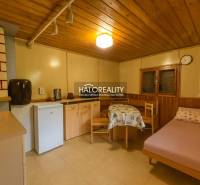 Szoba fa dekorációjú padlóval, egyszerű berendezéssel, ággyal és konyhasarokkal.