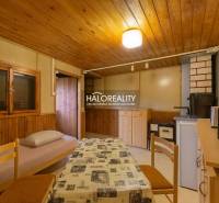 Belső tér asztallal, székekkel és szövet huzatú fotellel, fa dekorációjú padlóval.