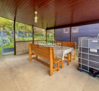 Fedett terasz asztallal, padokkal és kilátással a kertekre Bytčában.