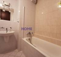 Fürdőszoba egy kétszobás lakásban káddal, mosdóval és tükörrel.