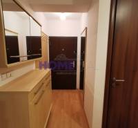 Előszoba egy 2 szobás lakásban fa dekoros padlóval, tükrökkel és szekrényekkel.