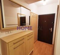 Folyosó egy kétszobás lakásban, fa dekoros padlóval, tükörrel és szekrénnyel.