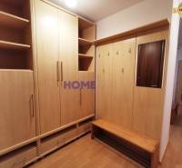 Előszoba egy kétszobás lakásban, fa dekorációjú bútorokkal és tükörrel.