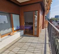 Erkély csempével, fa ablakokkal és kilátással a környékre egy 2 szobás lakásban.