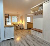 3 szobás lakás belső tere fa dekor padlóval és étkezőasztallal.