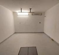 Tágas szoba fehér falakkal és világos megvilágítással egy háromszobás lakásban.