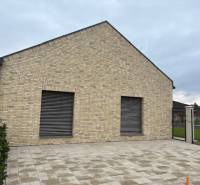 Családi ház a Tomášov-i Fialkova utcában téglafalú homlokzattal és kövezett udvarral.