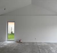 Fehér fal és betonpadló egy családi házban, készen az enteriőr befejezésére.