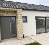 Családi ház Tomášovban, a Fialkova utcában, téglaburkolattal és tágas üvegajtókkal.