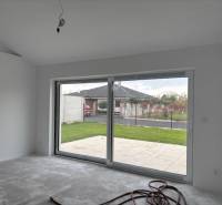 Családi ház üvegfallal és kilátással a kertre.