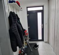 Családi ház előszobája, csempével, fogassal és cipőtartó polccal.