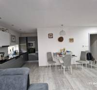 Családi ház belső tere konyhával, étkezőasztallal és fa dekorációjú padlóval.