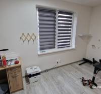 Szoba egy családi házban, fa dekoros padlóval, edzőpaddal és asztallal.