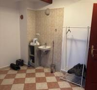 Iroda belső mosdóval, fogassal és csempézett padlóval.