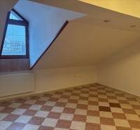 Tetőtéri iroda padlóburkolattal és ablakkal, radiátoros fűtéssel.