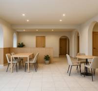 Finoman megvilágított üzlethelyiség boltívekkel, bútorokkal és burkolattal, kellemes környezetet teremtve.