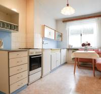 Konyha családi házban klasszikus felszereléssel, sarokban elhelyezett ülőhellyel és ablakkal.