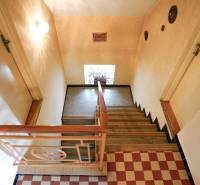 Lépcső fa korláttal és fa dekoros padlóval családi házban.