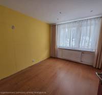 Szoba sárga fallal, ablakkal, finom függönyökkel és fa dekorációjú padlóval.