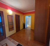 Színes folyosó a 4 szobás lakásban, fa dekoros padlóval, beépített szekrénnyel.