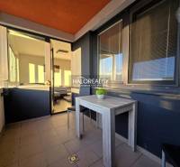 A kétszobás lakás erkélye Nagyszombatban, kilátással és teraszon lévő asztallal.