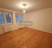 Családi ház szobája fa dekorációjú padlóval, nagy ablakokkal és radiátorokkal.