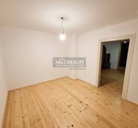 Egy üres szoba egy családi házban, fa mintázatú padlóval és egyszerű világítással.