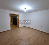 Családi ház belső tere fa dekorációjú padlóval és fehér falakkal.