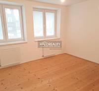 Szoba egy családi házban fa dekorációjú padlóval és fehér falakkal.