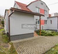 Családi ház Brvništeben piros tetővel és kövezett bejárati úttal.