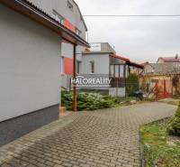 Burkolt járda és zöldterület egy családi ház mellett Brvnište-ben.