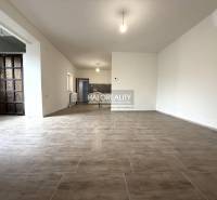 Tágas belső tér nagy ablakokkal és fa dekorációjú padlóval egy családi házban.