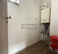 Családi ház technikai helyisége kazánnal és fa dekorációjú padlóval.