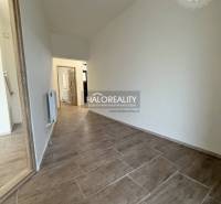 Családi ház belső tere fa dekorációjú padlóval és fehér falakkal.