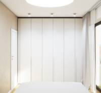 Fehér beépített szekrény a családi ház hálószobájában, fa dekor padlóval.