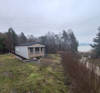 Ház a Fő utcán Újkelcsén, kilátással a vízfelületre és az erdőre.